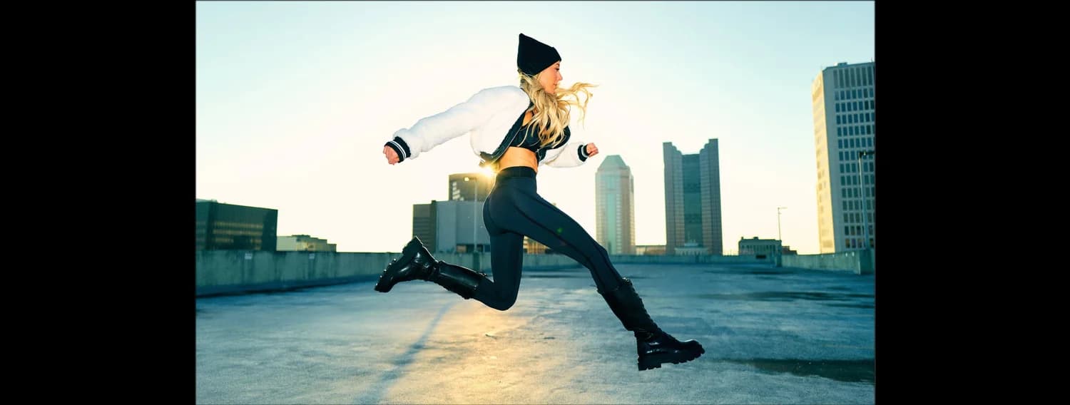 Jen mid-leap at sunrise with the Columbus skyline behind her