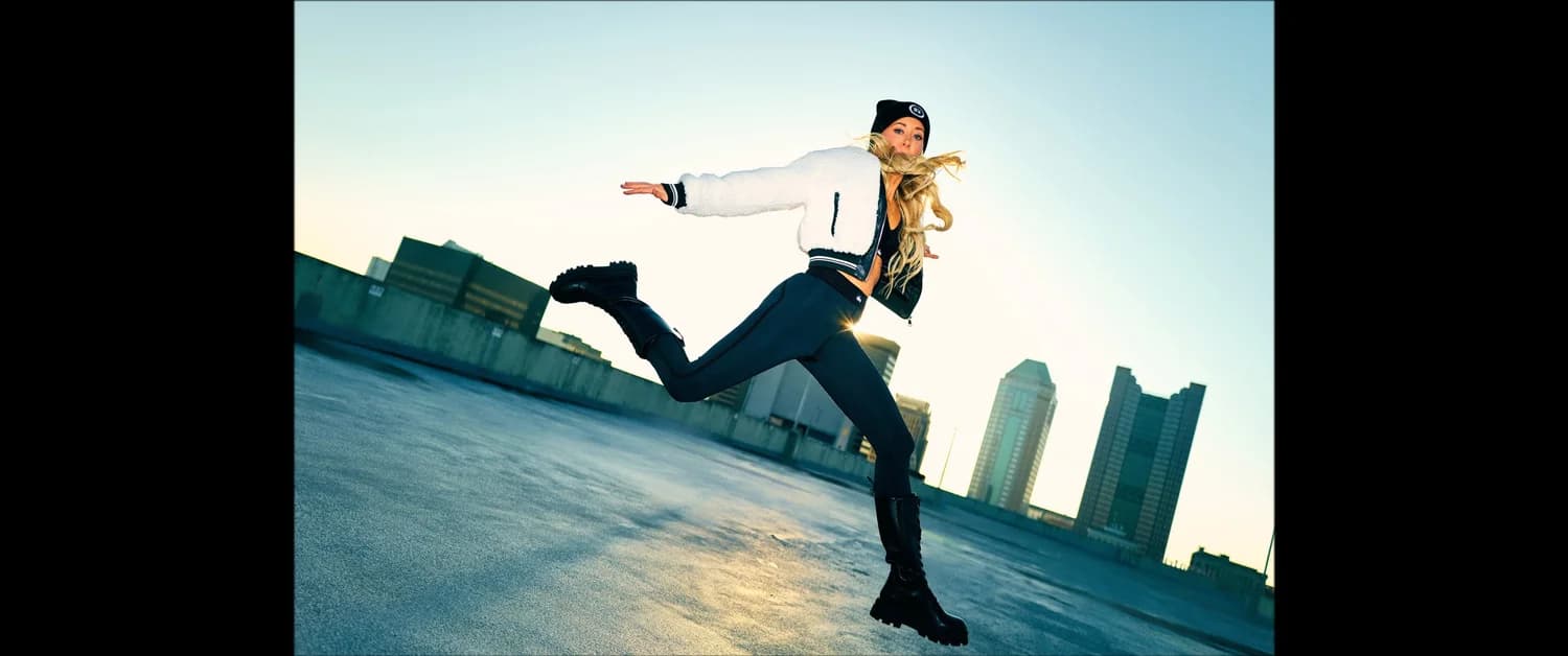 Jen in a dynamic kick pose on a downtown Columbus rooftop
